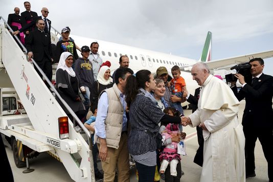 Le pape accueillant des réfugiés sur sol italien